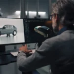 Ein Designer arbeitet an zwei Bildschirmen an der digitalen Modellierung eines Autos, um die Grundlage für die spätere physische Modellherstellung zu schaffen. Der Prozess verbindet digitale Entwürfe mit physischem Modellbau für die Fahrzeugentwicklung. Englisch: A designer works on two screens, digitally modeling a car to lay the foundation for later physical model build. The process combines digital design with physical model production in vehicle development.