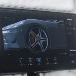 Ein Computermonitor zeigt ein 3D-Rendering eines Fahrzeugprototyps, bei dem insbesondere das Rad hervorgehoben wird. Die Software visualisiert verschiedene Materialien und Funktionen im Rahmen der Produktprüfung und der Simulation von Prototyp-Materialien. Das Bild illustriert den Einsatz digitaler Tools zur Analyse und Bewertung von Fahrzeugprototypen und ihren Komponenten. A computer monitor displays a 3D rendering of a vehicle prototype, with a focus on the wheel. The software visualizes different materials and features as part of product testing and prototype materials simulations. The image illustrates the use of digital tools to analyze and evaluate vehicle prototypes and their components.