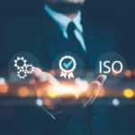 Ein Geschäftsmann hält Symbole für Zertifizierung, ISO-Standards und Qualität in seiner Hand. Diese Symbole stehen im Zusammenhang mit der PSS-Validierung, bei der die Konformität eines Produkt-Service-Systems mit internationalen Standards und Qualitätsanforderungen überprüft wird. A businessman holds icons representing certification, ISO standards, and quality in his hand. These symbols relate to PSS validation, where a product-service system's compliance with international standards and quality requirements is assessed.